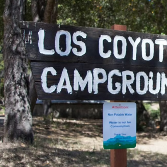 Aerial view of Los Coyotes Campground, showing RVs, tents, and trails amidst lush green landscapes in Warner Springs, California.