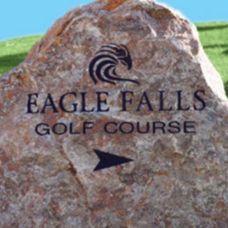 Aerial view of Eagle Falls Golf Course with lush green fairways, palm trees, mountains, and blue skies in Indio, California.