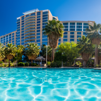 Agua Caliente Resort with a modern building facade, palm trees, and a welcoming entrance signage.