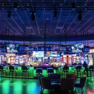 The image shows the Agua Caliente Casino Cathedral City entrance, featuring modern architecture and a well-lit exterior at night.