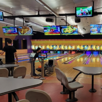 The image shows the exterior of Canyon Lanes bowling alley with a bright sign and palm trees under a clear blue sky.