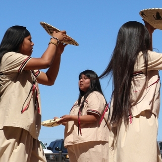 Exterior of Ak-Chin Him-Dak Eco-Museum, a beige building with a red roof, surrounded by desert landscape and clear blue sky.