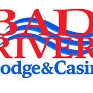 Logo: Bad River text in red Lodge  & Casino in blue with three narrow wave graphic in the background 